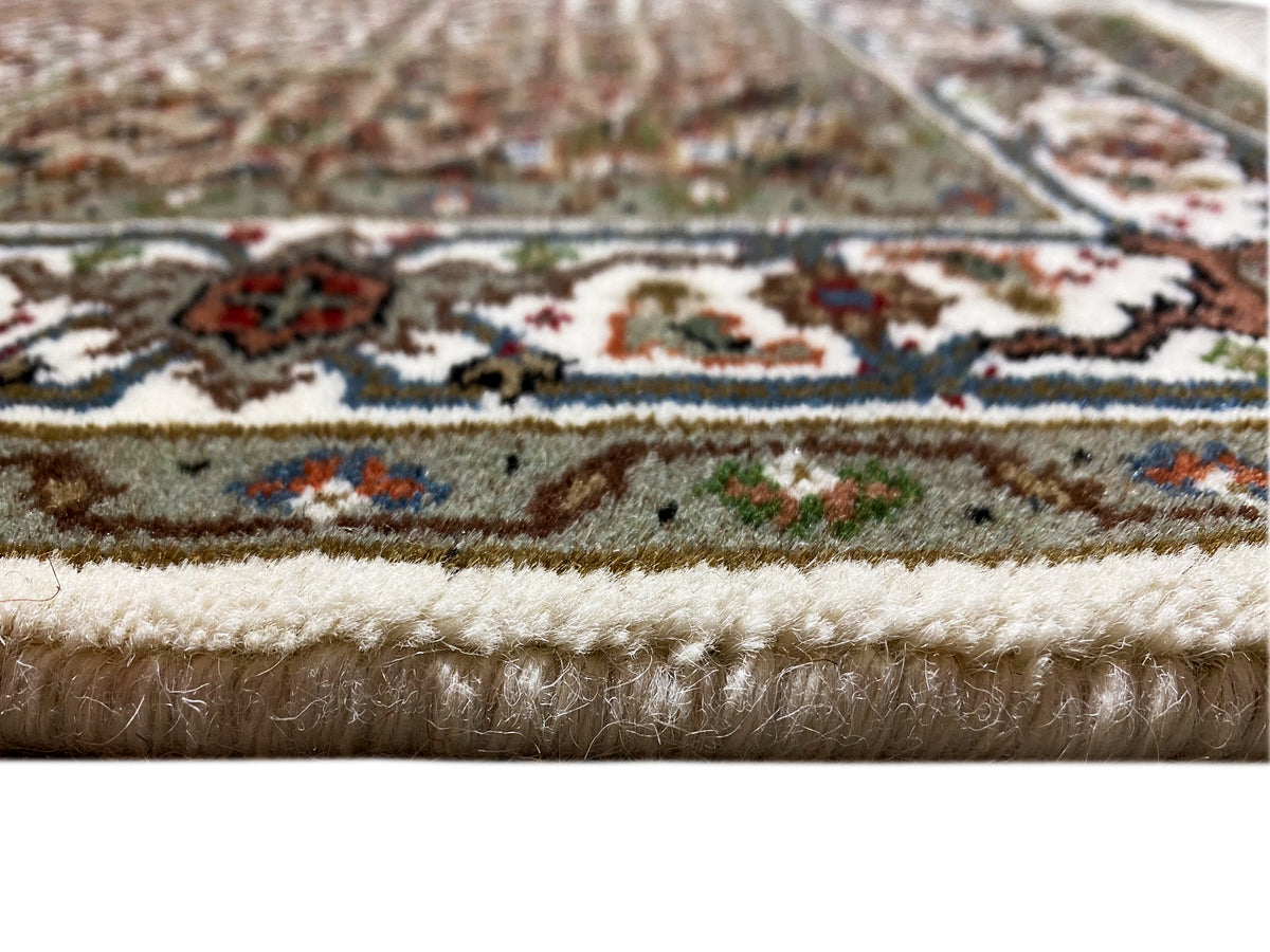 Indo Täbriz rug: close-up of the pile direction and multicolored ornamental border