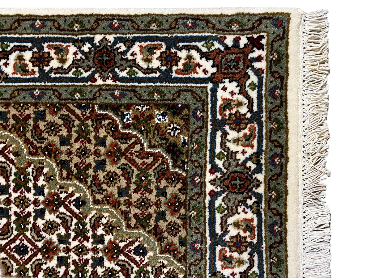 Indo Tabriz rug: corner detail with borders, visible edge, and fringes