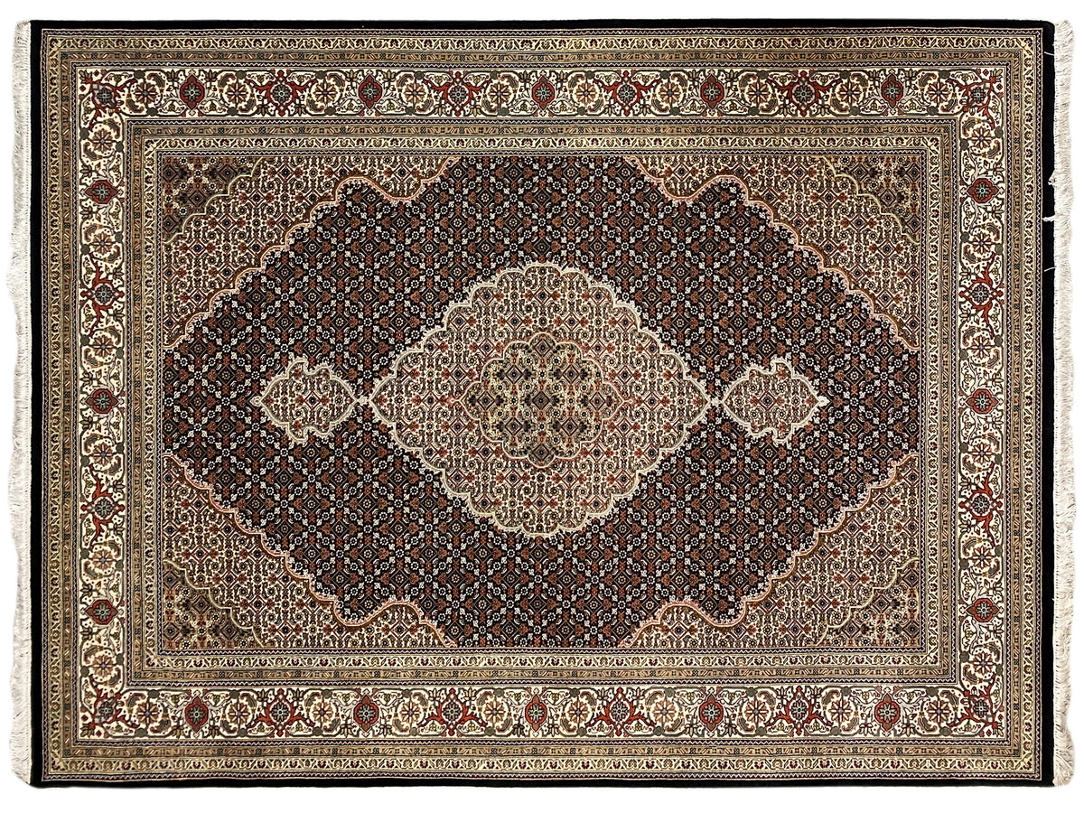 Tabriz-style rug with a large medallion, surrounding border, and ornamental friezes