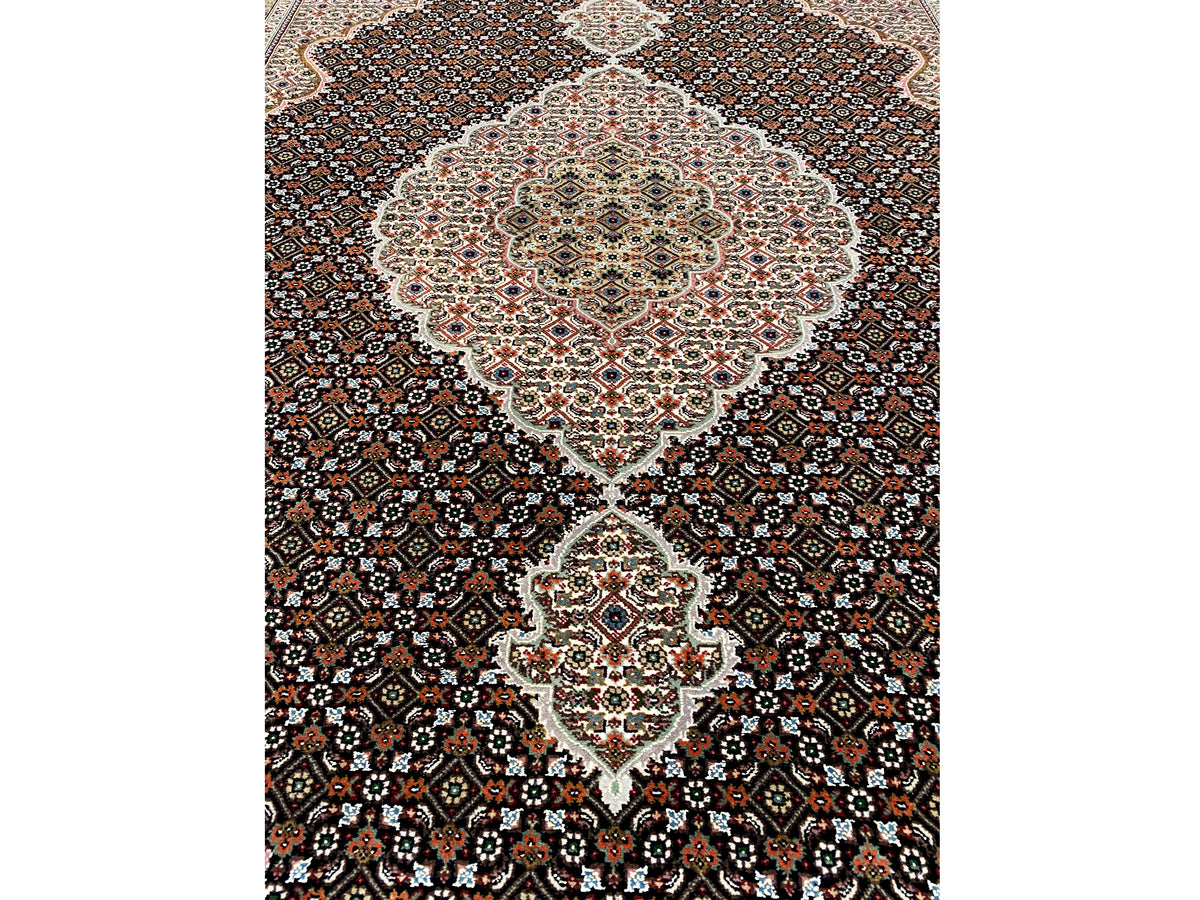 Indo Tabriz rug with a light medallion, dark pattern, and border trim