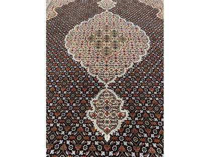 Indo Tabriz rug with a light medallion, dark pattern, and border trim