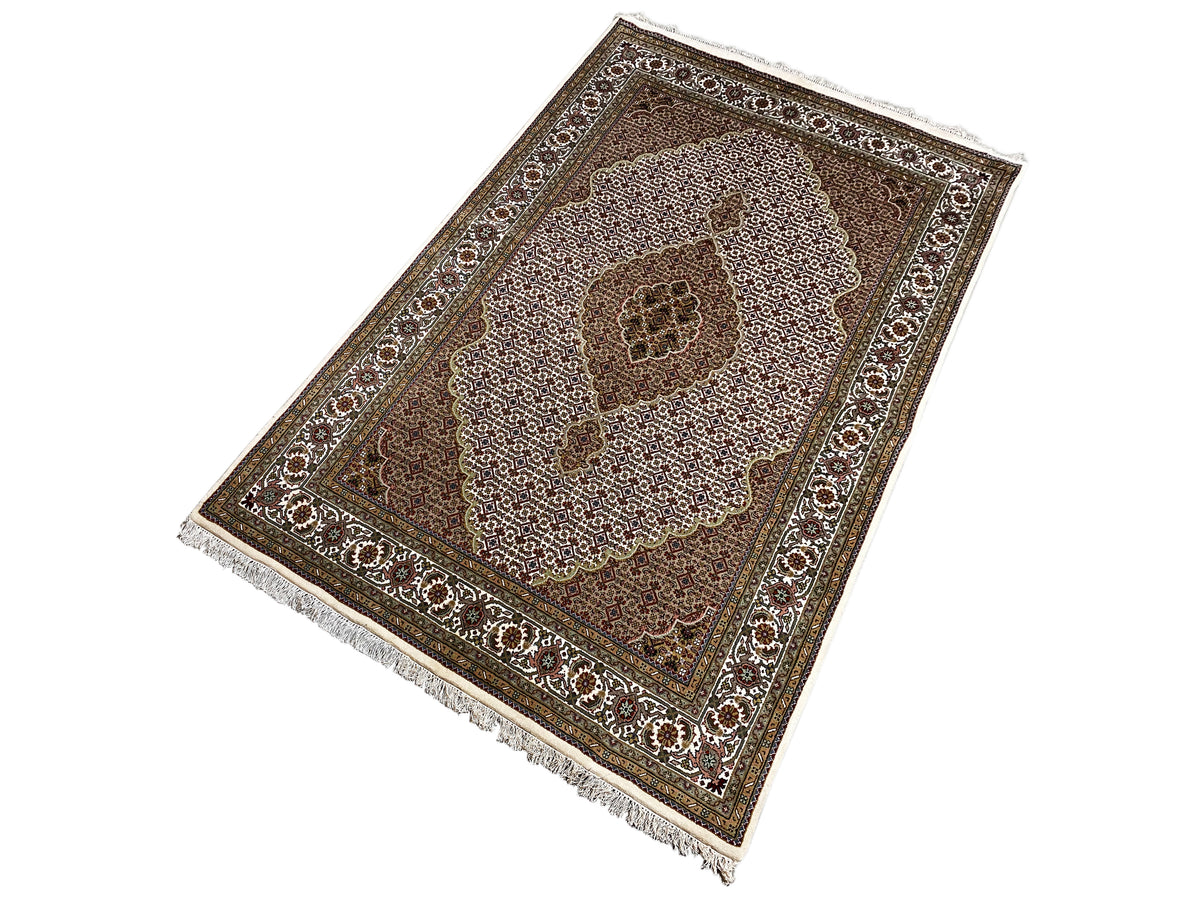 Indo Tabriz carpet: diagonal view with border ornaments and fringe along the edge