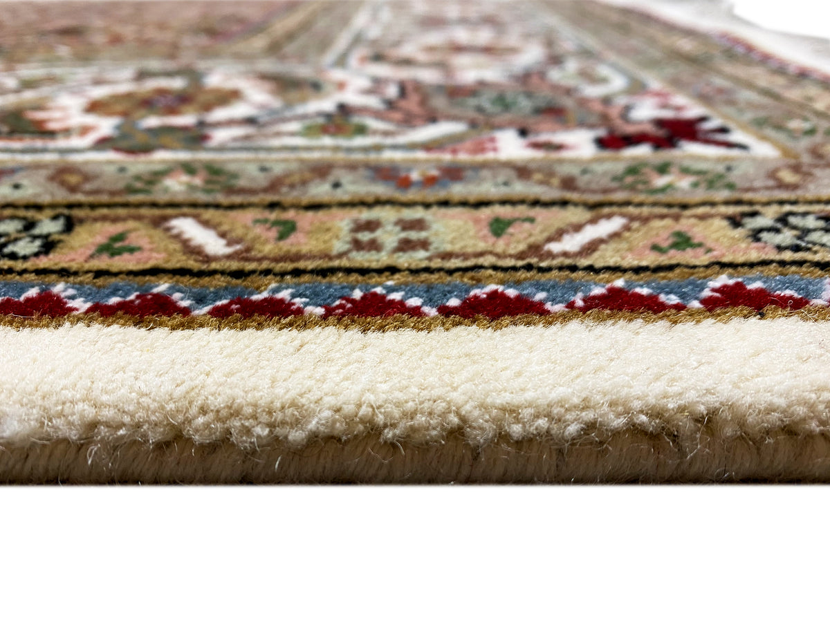 Indo Tabriz rug: close-up of the edge with fringe, beige and color accents