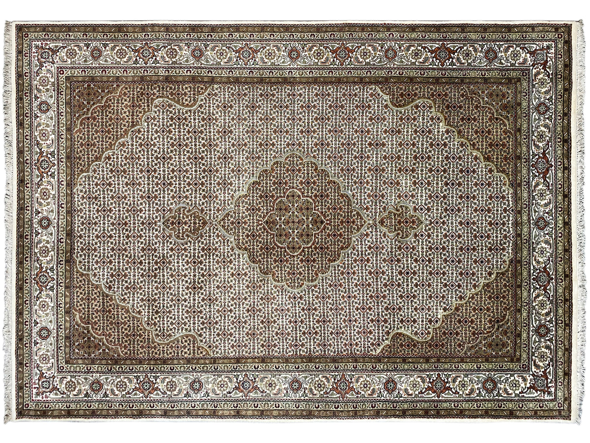 Carpet detail: large, light medallion on a brown field with a decorative border.