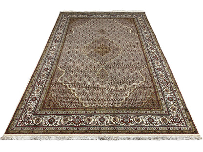 Rug laid flat, central floral motif area, and border with ornamental bands