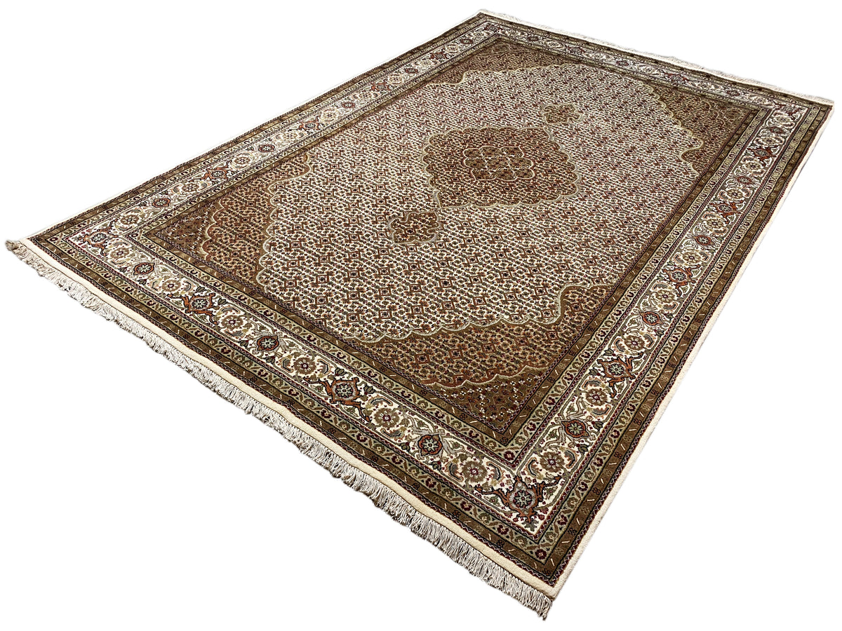 Beige/brown rug with a central ornament, an all-around border, and tassel fringes on the sides.