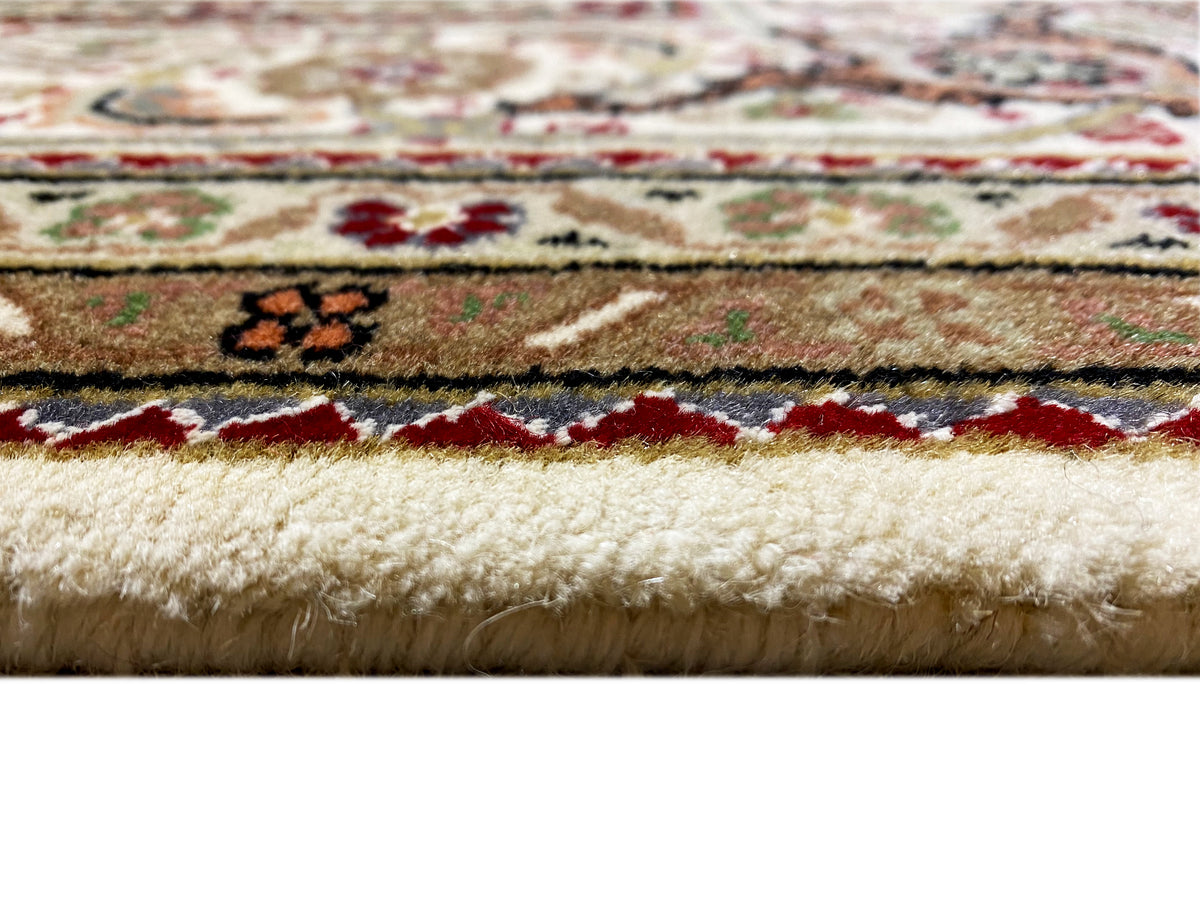 Carpet edge in detail: short pile, multicolored stripe patterns, and light-colored fibers.