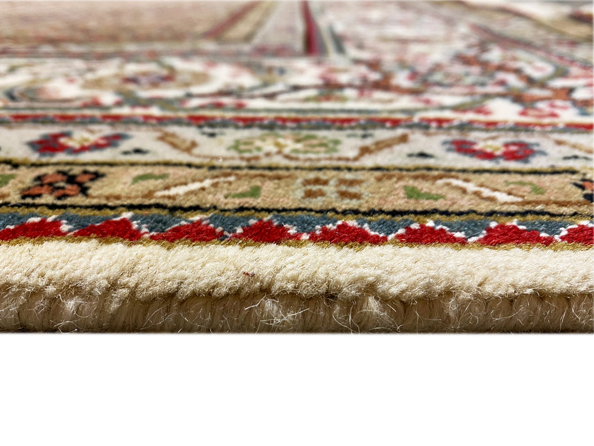 Close-up of a carpet edge with fringes, multicolored decorative borders, and dense pile