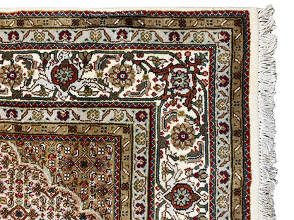 Carpet detail with border strips, floral ornaments, and overlocked thread fringes along the edge