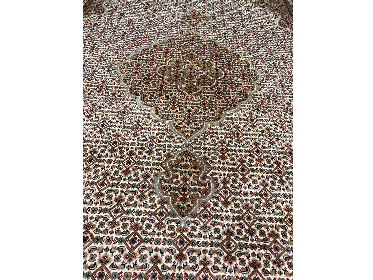 Close-up of the rug’s central medallion: brown-beige pattern with fine dotted ornamentation.