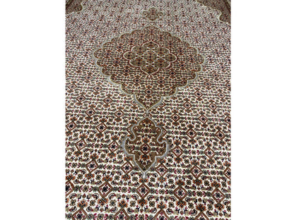 Close-up of the rug’s central medallion: brown-beige pattern with fine dotted ornamentation.