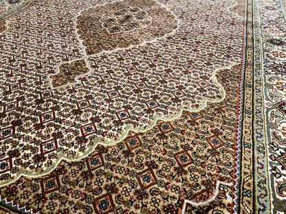 Indo Tabriz rug close-up: dense pattern, border, and medallion in brown/cream
