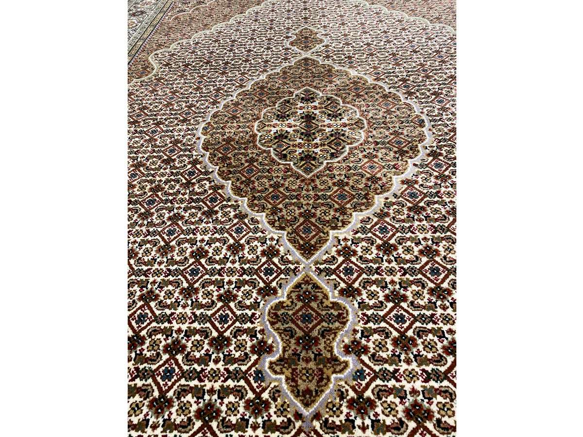 Rug with an ornamental medallion in cream, brown, and dark green
