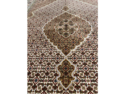 Rug with an ornamental medallion in cream, brown, and dark green