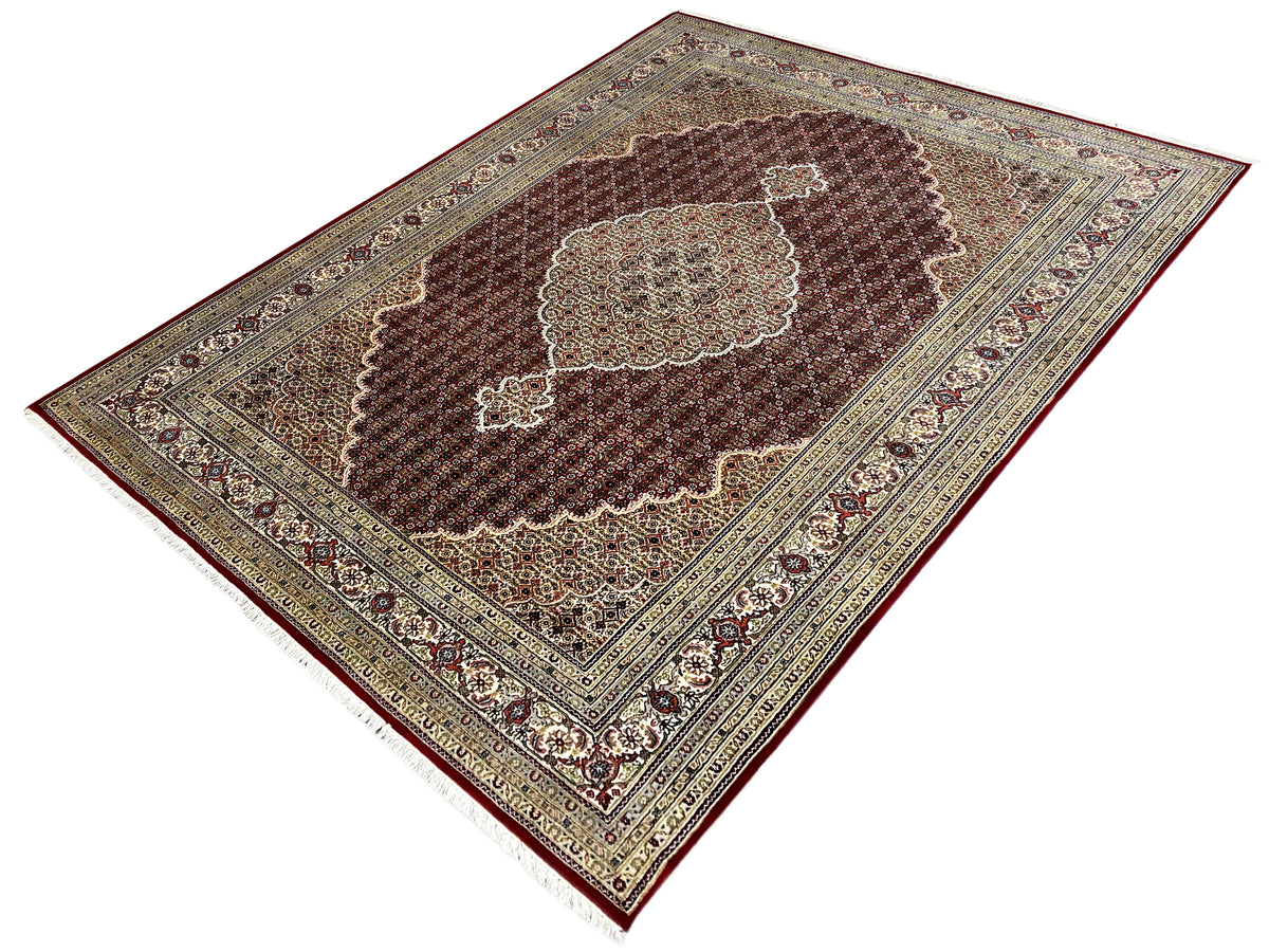Indo Tabriz carpet angled view with a central ornament and decorative border lines