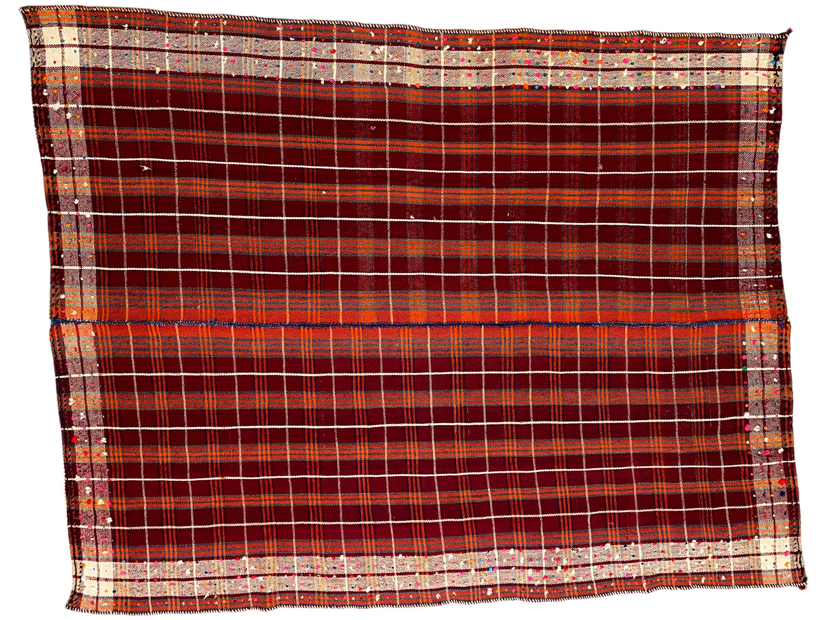 Rectangular rug with a wide border at the bottom and a red checkered grid with beige stripes