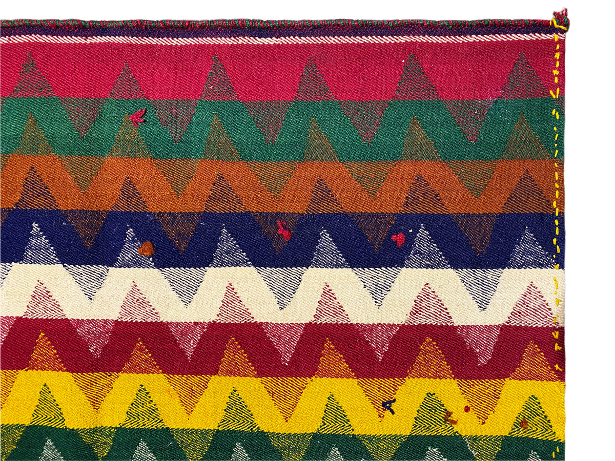 Jajim rug detail with colorful mountain/zigzag motifs in red, green, blue and yellow