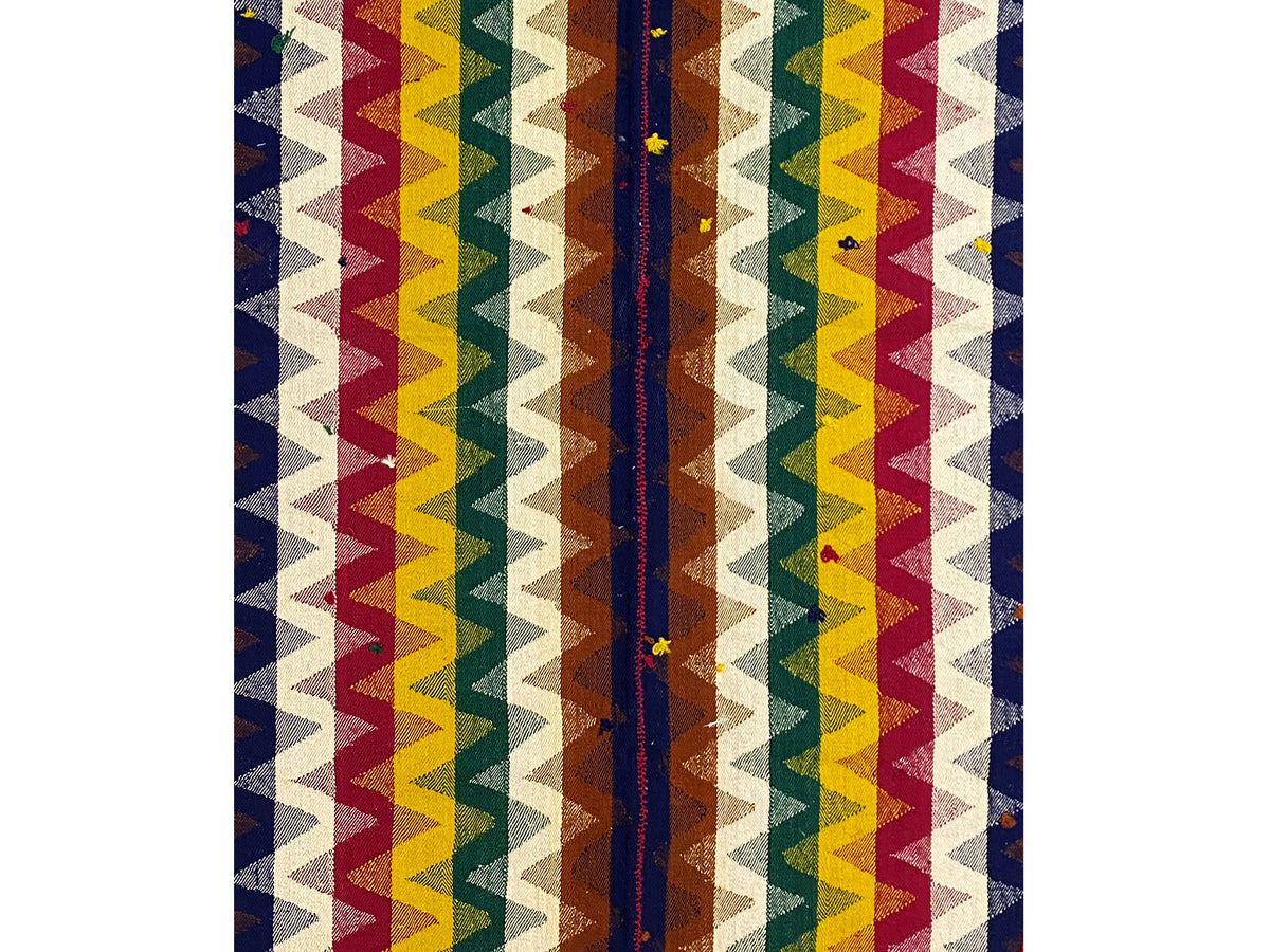 Close-up of a jajim rug: vertical zigzag stripes in blue, red, yellow, and cream