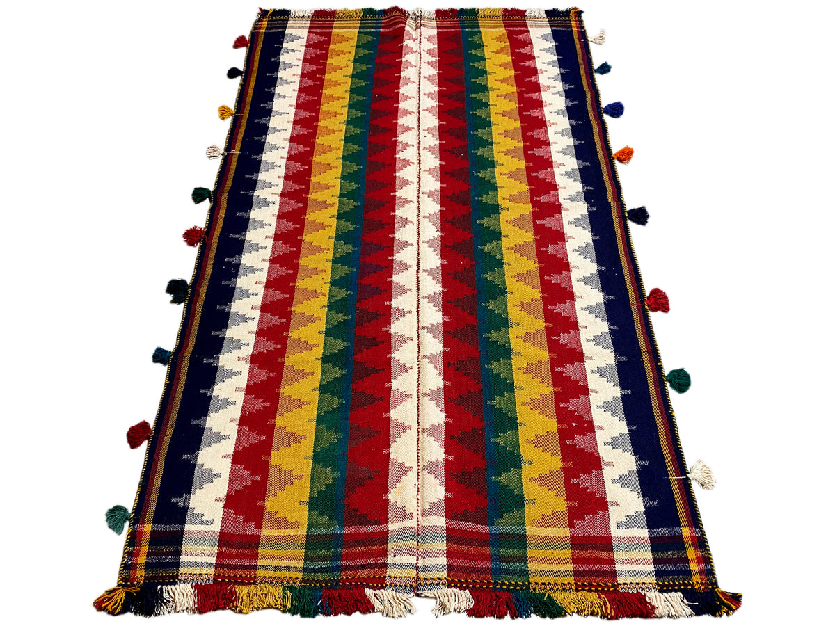 Jajim rug in a vertical view: striped design with pom-poms and a fringed edge