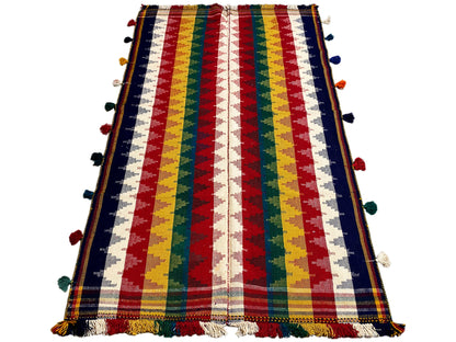 Jajim rug in a vertical view: striped design with pom-poms and a fringed edge