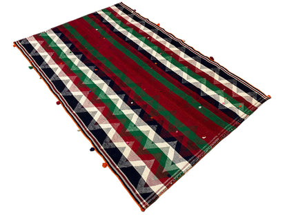 Jajim rug at an angle: clear zigzag and stripe patterns in red and green