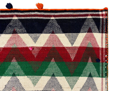 Close-up of a Jajim rug: bold triangular and striped patterns with orange tassels