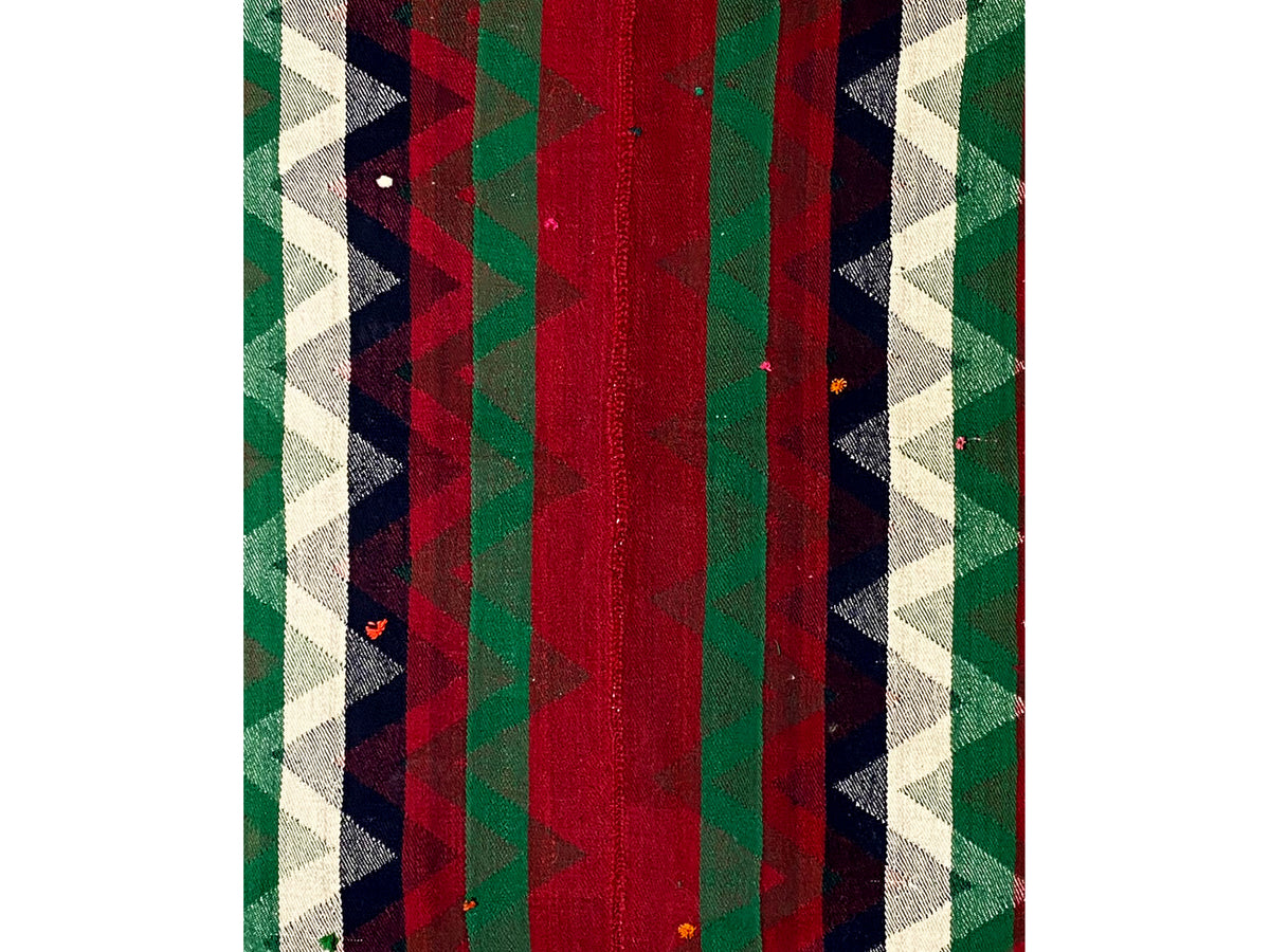 Detailed view of Jajim rug: vertical stripes in red, green, and dark areas