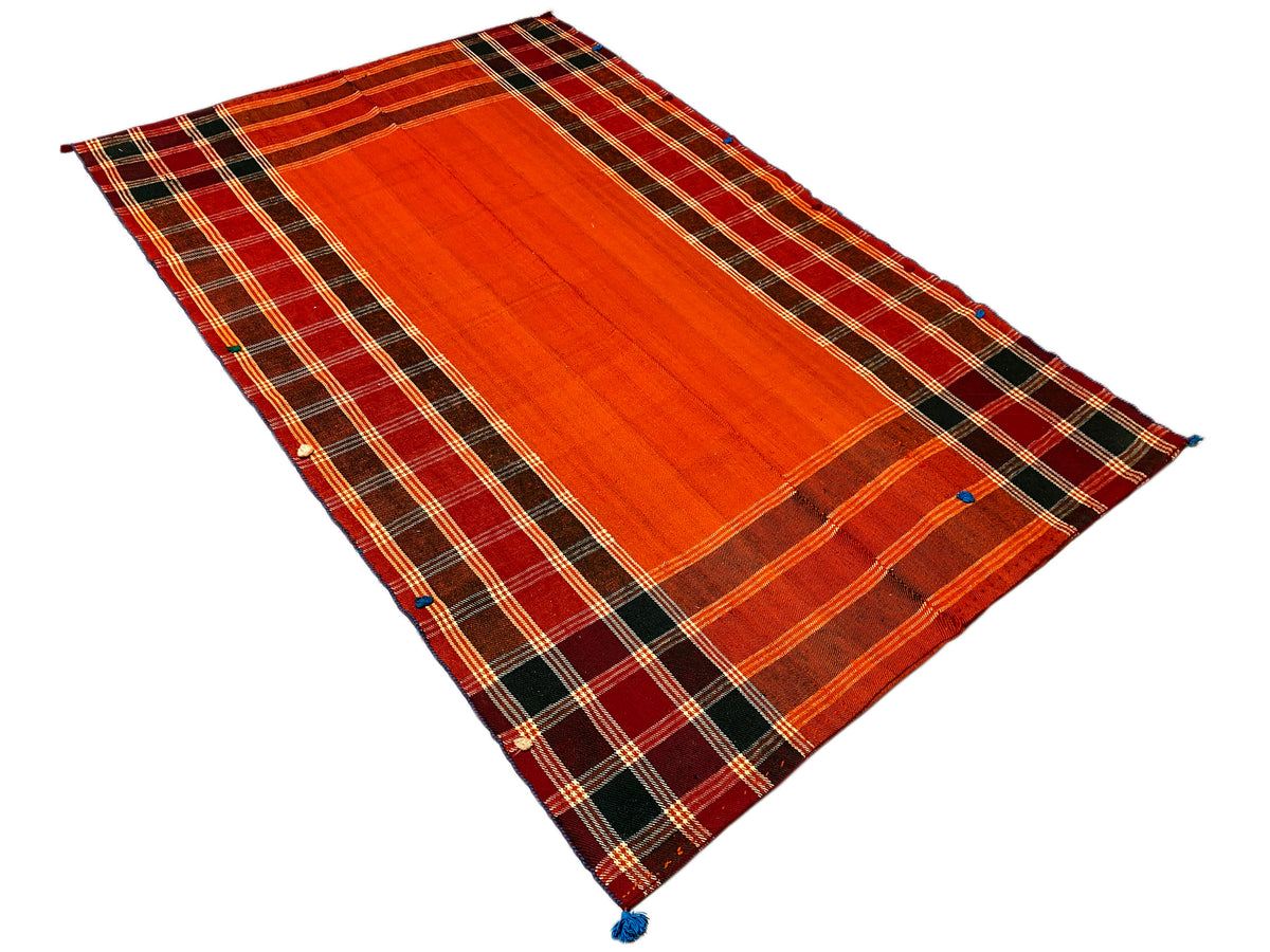 Triangle-like view of Jajim rug: red-orange central stripe, dark checkered border