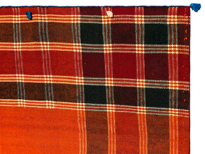 Detail of the Jajim rug: bold red-orange checkered pattern with black areas and white lines
