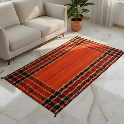 Jajim rug in the living room: red-orange with a black checkered pattern and white/yellow lines, blue tassels