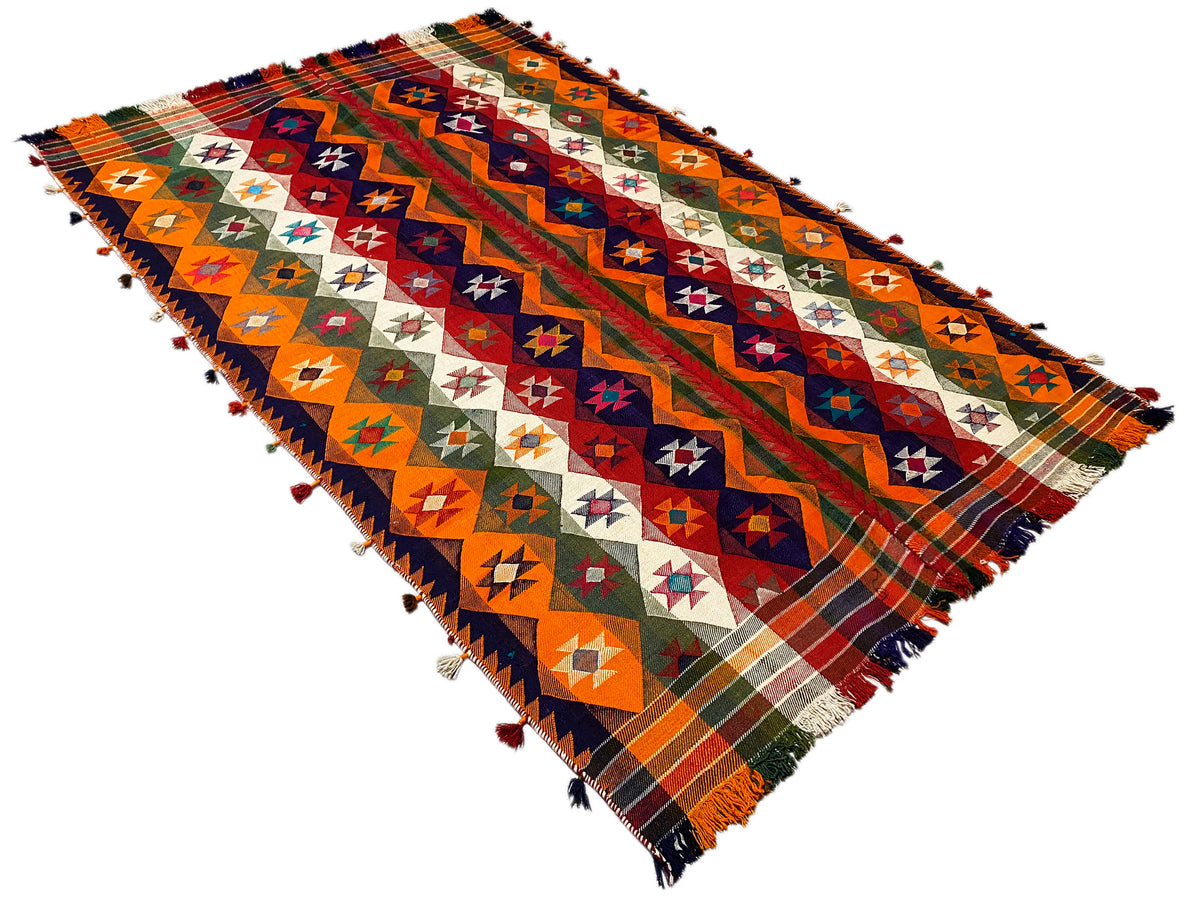 Jajim rug at an angle: multicolored rows with diamonds and crosses, fringes