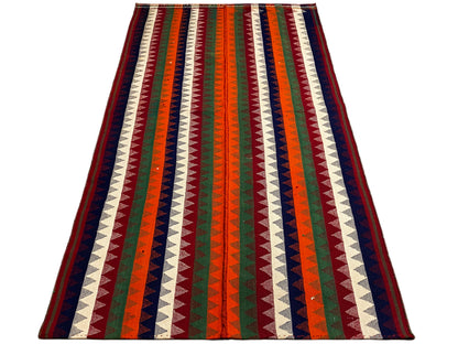 Jajim rug in an angled view: multicolored zigzag stripes with a dark border