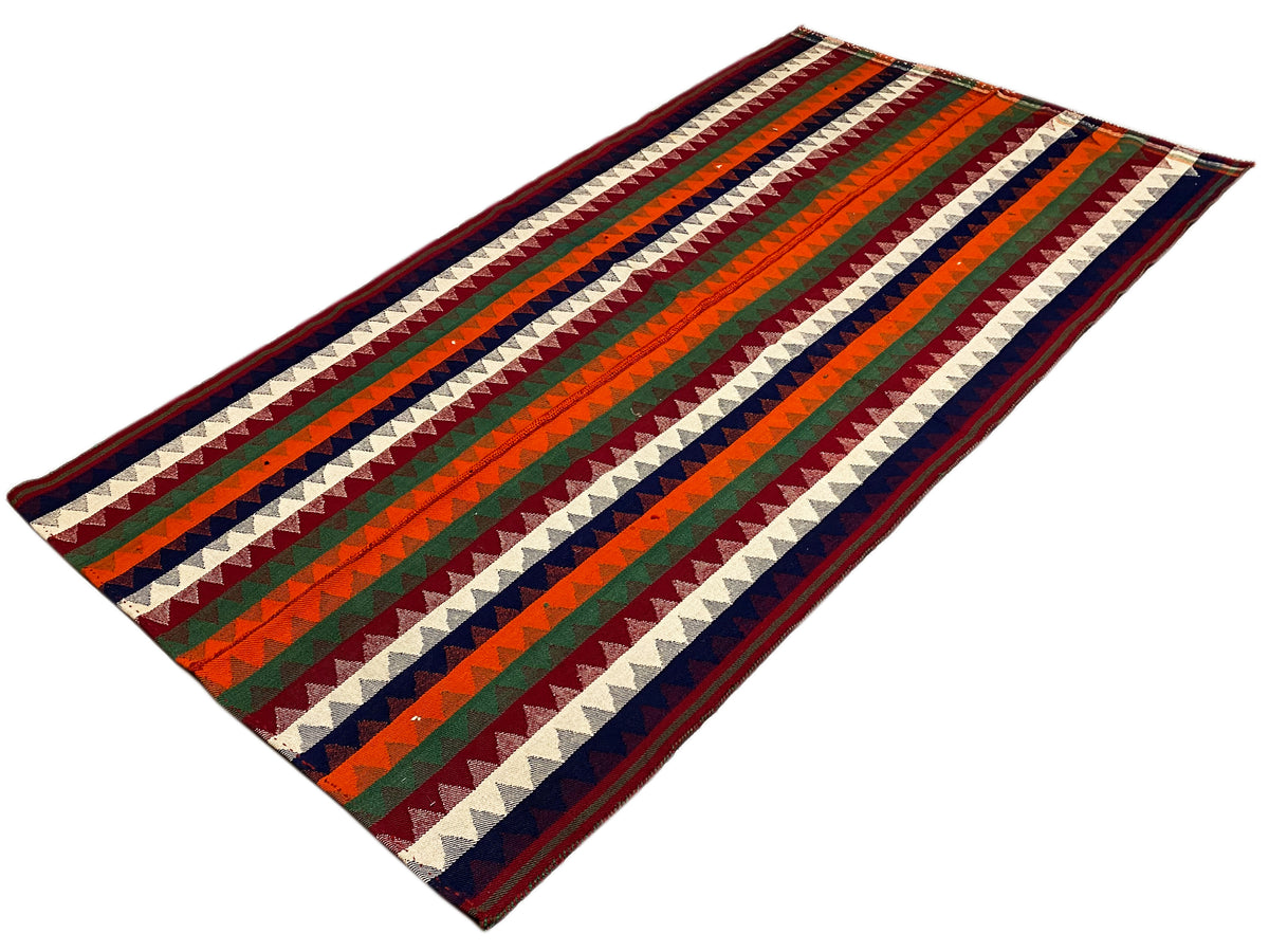 Jajim rug laid flat: diagonal striped pattern in green, red, blue, and cream