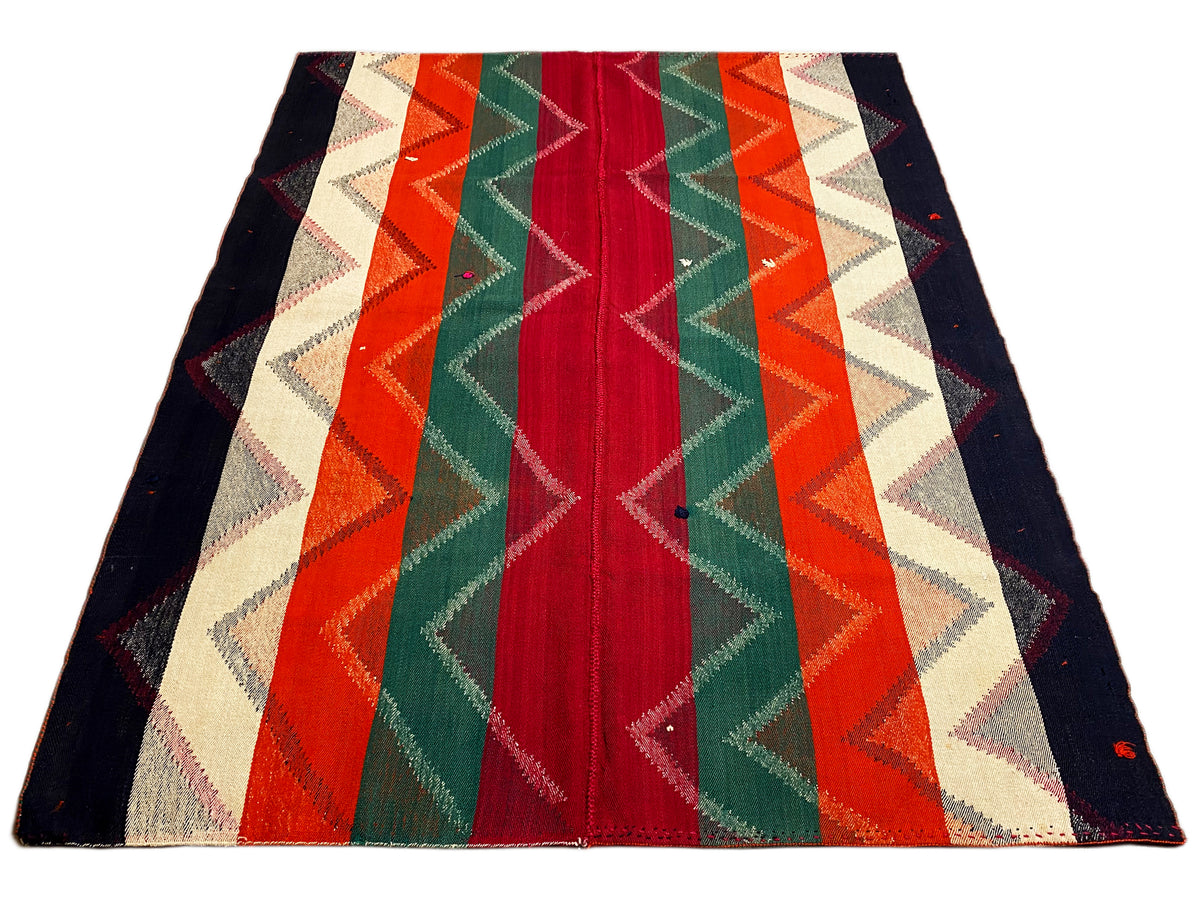 Rug with a geometric zigzag and stripe pattern in red, green, orange, and dark blue