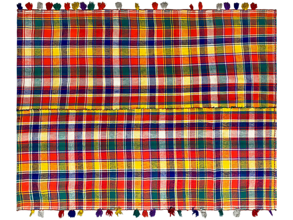 Jajim rug close-up: colorful plaid pattern, visible fringes along the edges
