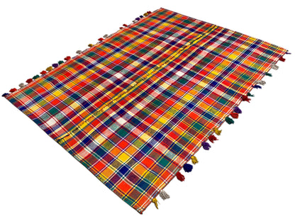 Jajim rug spread out diagonally, checked, with fringes along the edges