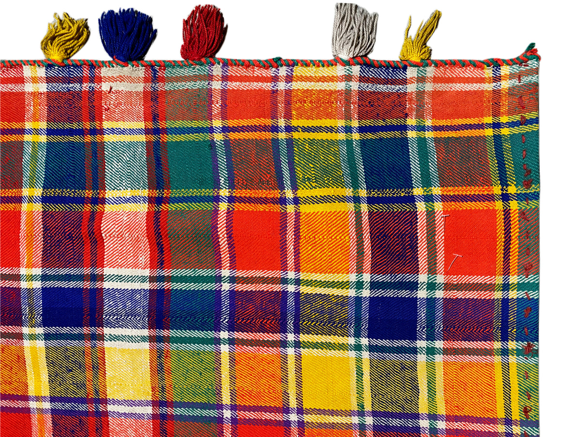 Jajim rug close-up: checked fabric with colorful tassels along the edge