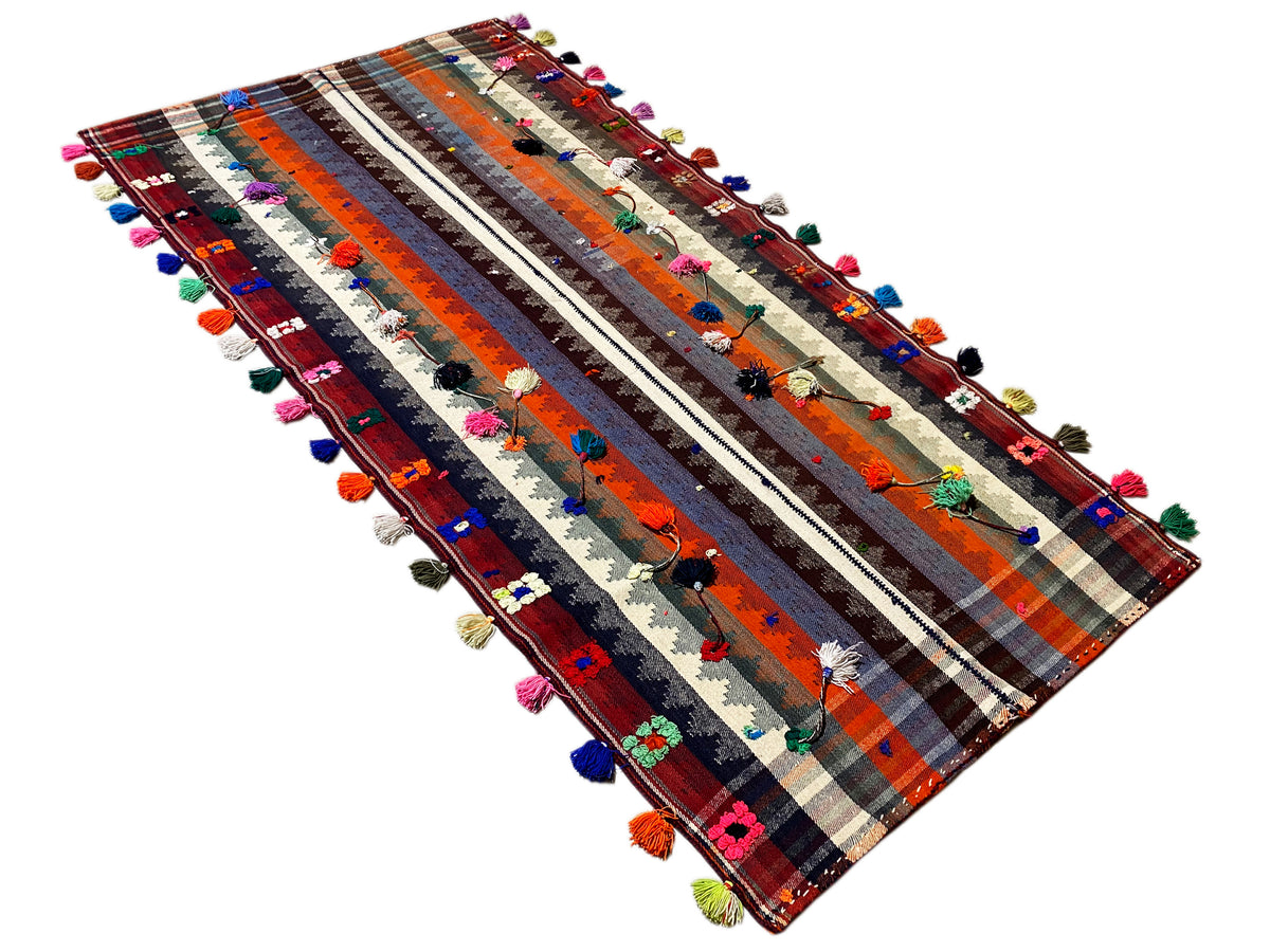 Jajim rug with a diagonal view, stripes, and colorful tassels along the edges