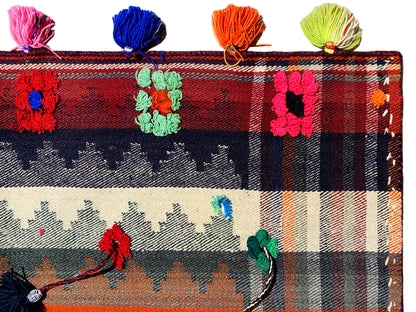 Close-up: Jajim rug with a checkered pattern, floral motifs, and multicolored tassels