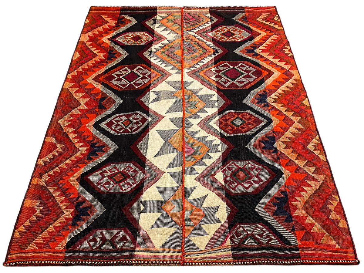 Jajim rug shown diagonally, symmetrical medallions in red, black, and cream