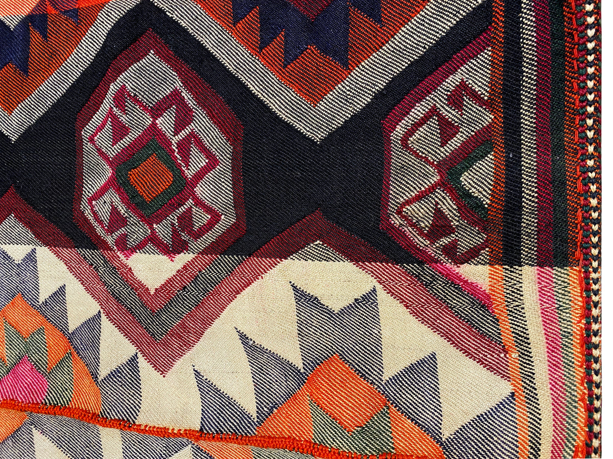 Jajim rug detail: diamond pattern and zigzag border in red, black and cream