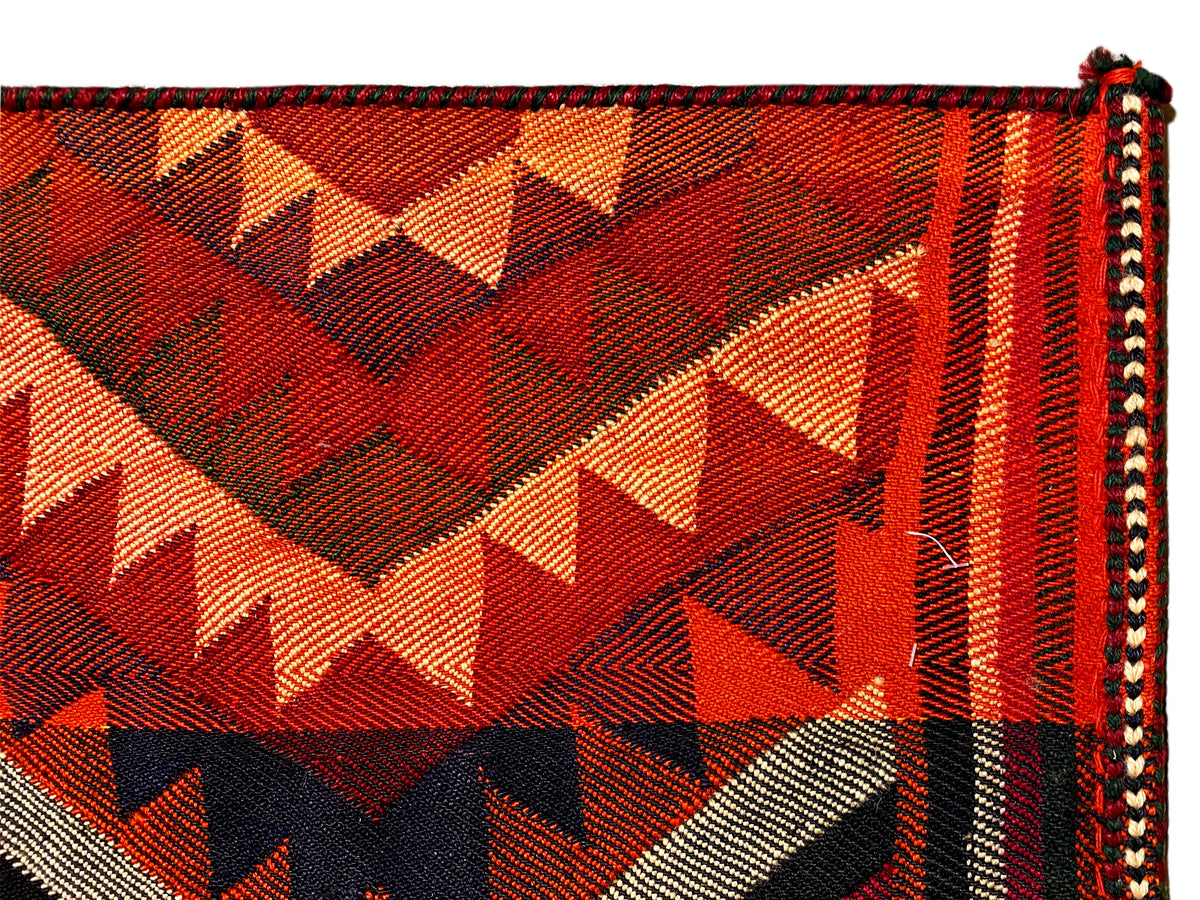 Close-up of a Jajim rug: triangles and zigzags in orange, red, black, and cream