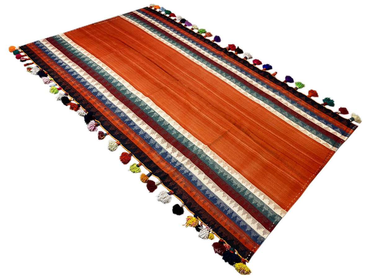Jajim rug spread diagonally: terracotta, striped border, tassels in various colors
