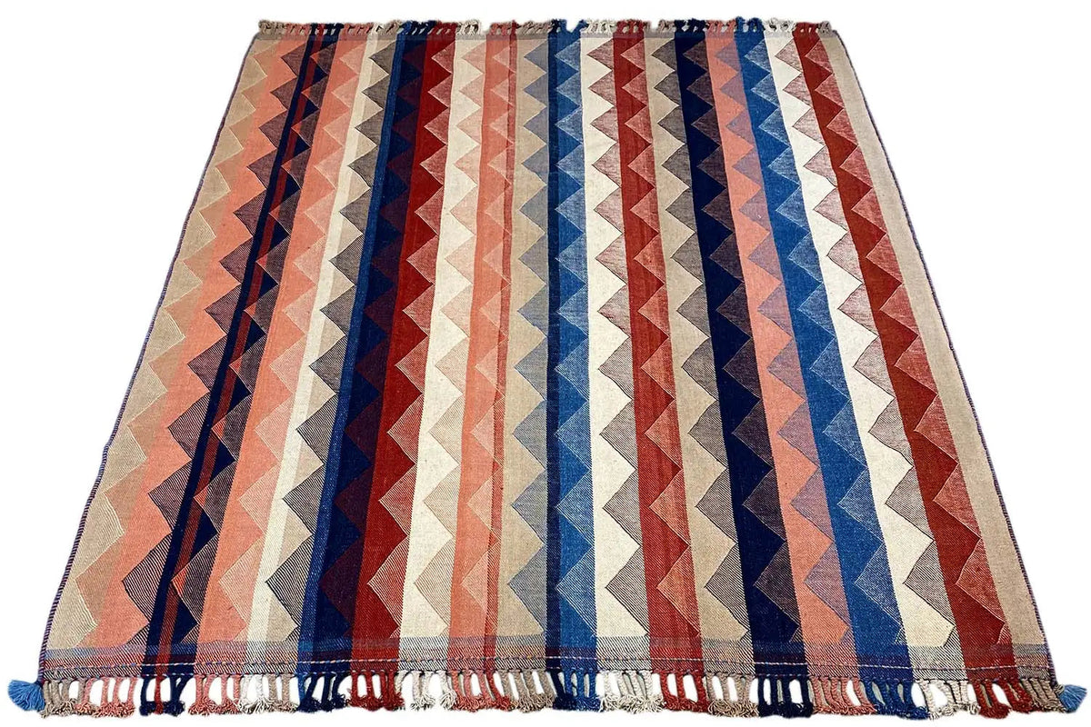 Rectangular rug with a zigzag pattern in beige, blue, red, and white stripes, fringes
