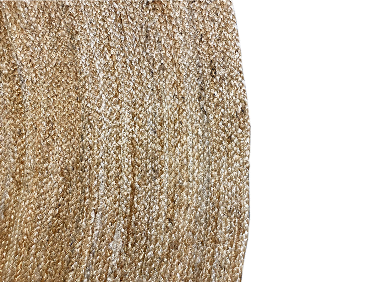 Jute rug edge with a dense, woven texture and light-colored fibers