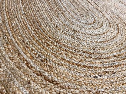 Close-up of the surface: woven jute rug with a spiral pattern, beige-brown fibers