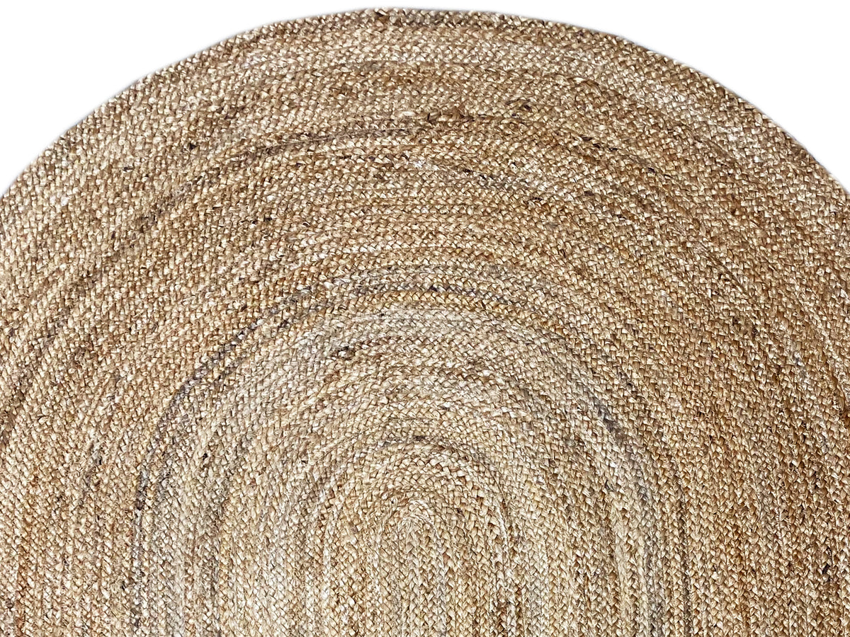 Close-up: Jute rug showing beige woven fabric and a rolled spiral motif