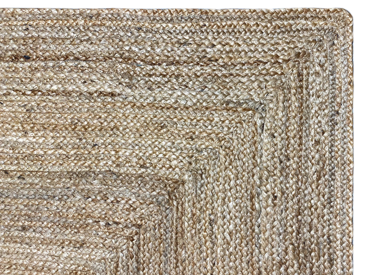 Jute rug close-up: natural beige, tightly woven surface with patterned lines.