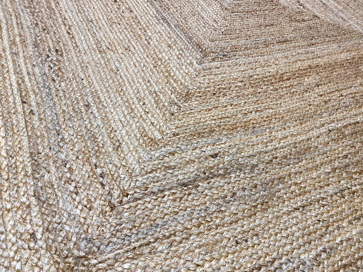 Close-up of a jute rug’s weave, natural beige with embossed lines.