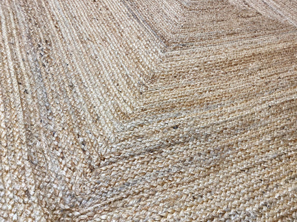 Close-up of a jute rug’s weave, natural beige with embossed lines.